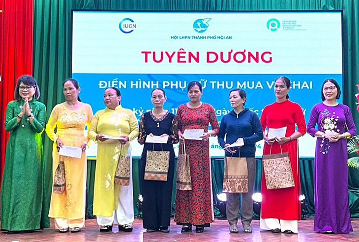 Buổi lễ đặc biệt của những người phụ nữ nhặt ve chai - Ảnh 1. Những người làm nghề ve chai và các ngành nghề khác bận áo dài lên nhận hoa, quà tại TP Hội An vào sáng 7-3 - Ảnh: THÙY ANH