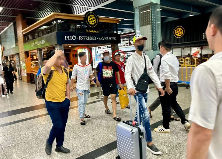 Bát nháo, chèo kéo khách ở sân bay Tân Sơn Nhất, sao chưa dẹp được?- Ảnh 1. Một số lái xe taxi (khoanh tròn) chào mời khi khách vừa rời sân bay Tân Sơn Nhất trưa 27-5 - Ảnh: T.T.D.