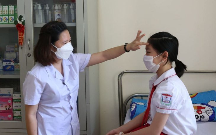 Bộ Nội vụ phản hồi đề xuất bổ sung biên chế y tế học đường- Ảnh 1. Nhân viên y tế học đường ở Hạ Long (Quảng Ninh) hướng dẫn kiểm tra sức khỏe cho học sinh - Ảnh: TRẦN THANH